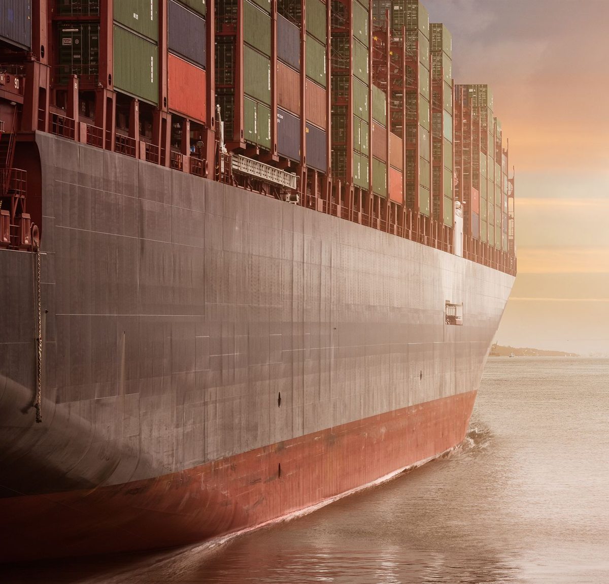 Navio porta-contêineres navegando ao entardecer